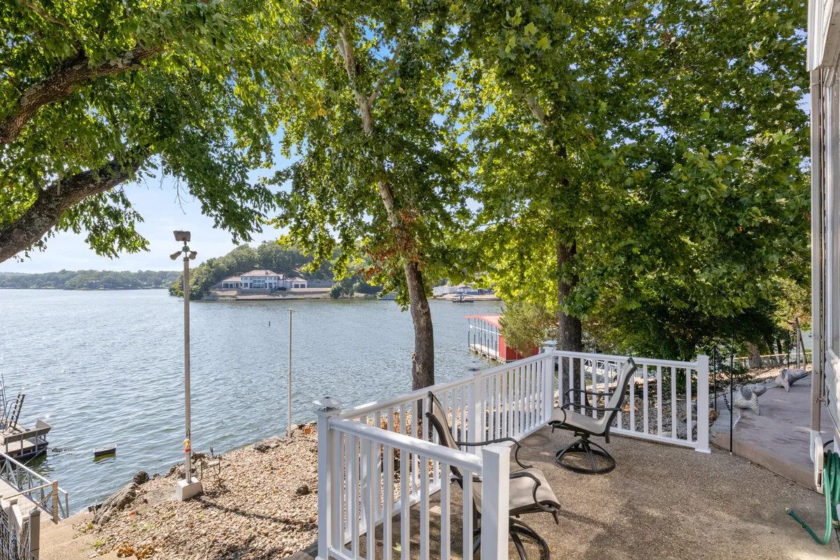 A serene waterfront area with benches and trees, perfect for relaxing, fishing, or gathering to watch the sunset. The scene exudes peacefulness, suggesting early mornings or relaxing evenings spent by the water with friends or family.